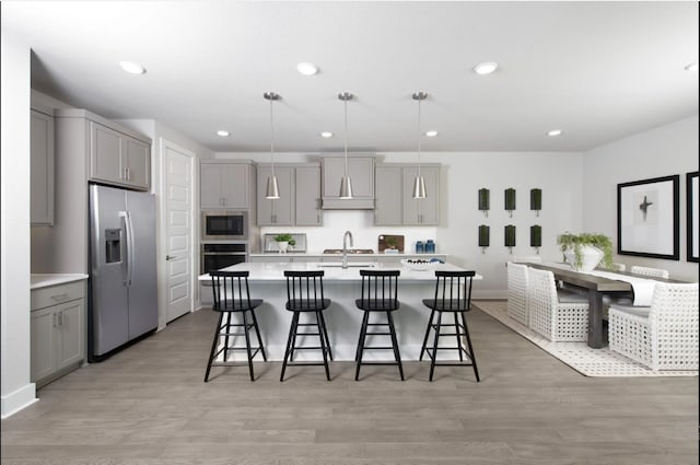 1406 Fennel, Argyle, TX 76226 - kitchen with appliances with stainless steel finishes, gray cabinets, light countertops, a kitchen island with sink, and recessed lighting