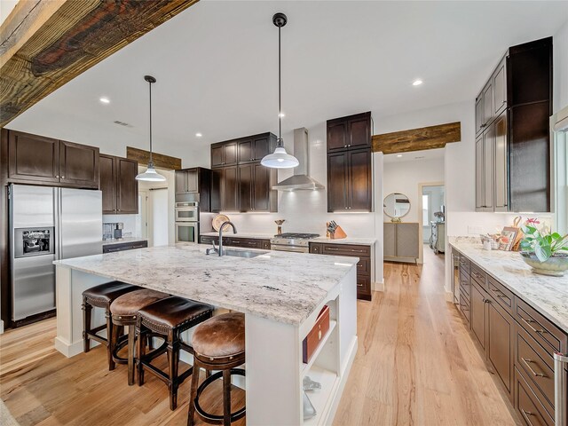6362 Belz Rd, Sanger, TX 76266 - kitchen with appliances with stainless steel finishes, a sink, wall chimney range hood, a large island, and light wood-style flooring