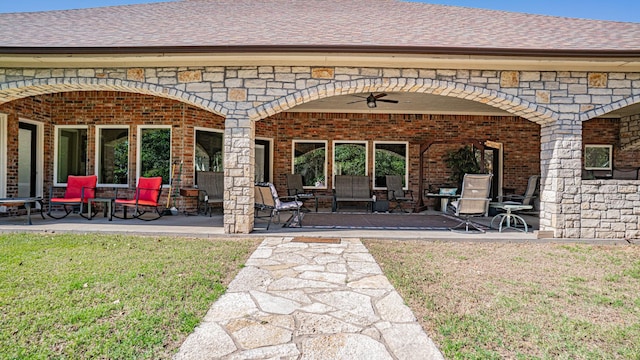 1851 Rock Church Hwy, Tolar, TX 76476 - back of property with ceiling fan, brick siding, a patio, a lawn, and roof with shingles