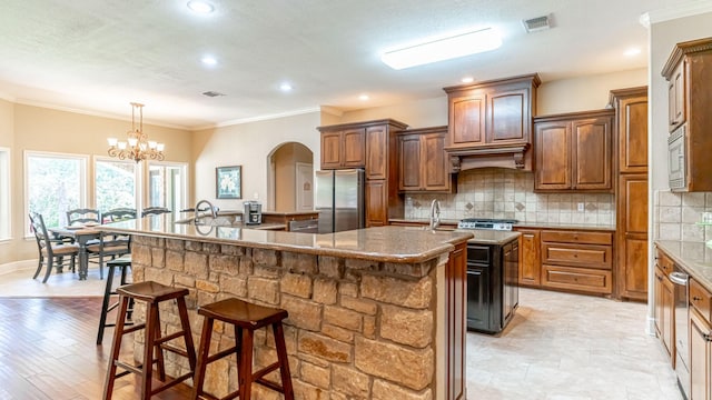 1851 Rock Church Hwy, Tolar, TX 76476 - kitchen with freestanding refrigerator, a spacious island, tasteful backsplash, a kitchen breakfast bar, and crown molding
