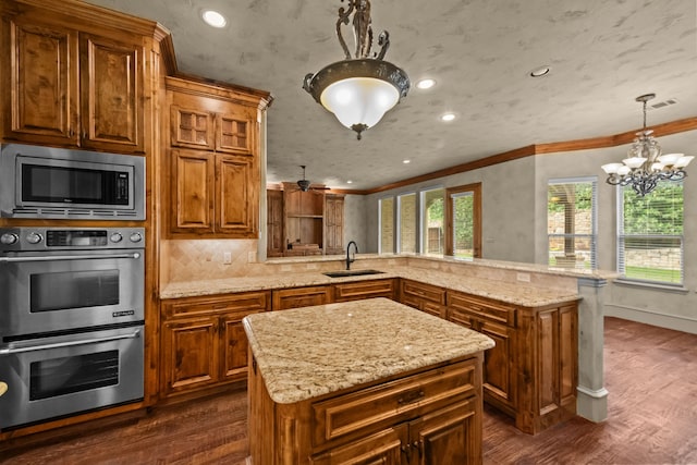608 Guadalupe Rd, Keller, TX 76248 - kitchen featuring appliances with stainless steel finishes, a sink, a peninsula, dark wood finished floors, and brown cabinets