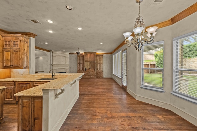 608 Guadalupe Rd, Keller, TX 76248 - kitchen with crown molding, a sink, a chandelier, dark wood-style floors, and a kitchen breakfast bar