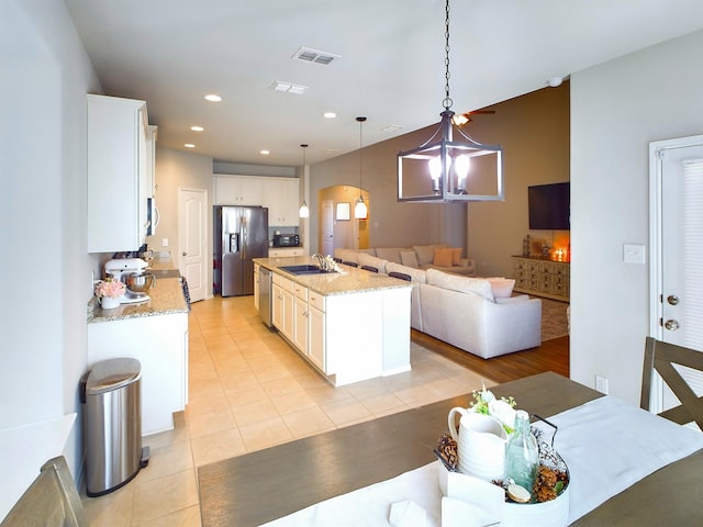4329 Aldridge Ln, Fort Worth, TX 76036 - kitchen featuring stainless steel appliances, arched walkways, open floor plan, light tile patterned flooring, and a sink
