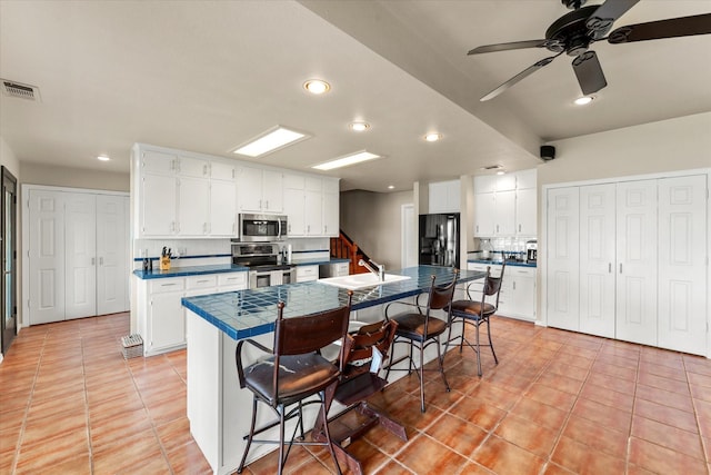 7016 Fm 3054, Malakoff, TX 75148 - kitchen featuring stainless steel appliances, a sink, a kitchen breakfast bar, light tile patterned floors, and recessed lighting