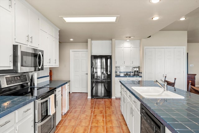 7016 Fm 3054, Malakoff, TX 75148 - kitchen with black appliances, tile countertops, decorative backsplash, a sink, and white cabinetry