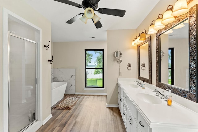 7016 Fm 3054, Malakoff, TX 75148 - bathroom with wood finished floors, a shower stall, a soaking tub, baseboards, and double vanity
