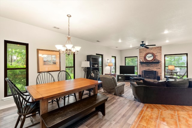 7016 Fm 3054, Malakoff, TX 75148 - dining area featuring a chandelier, ceiling fan, a brick fireplace, light wood-type flooring, and recessed lighting