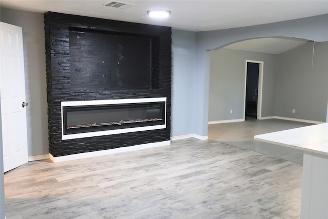 494 Lannius Rd, Dodd City, TX 75438 - unfurnished living room with arched walkways, wood finished floors, a fireplace, and baseboards