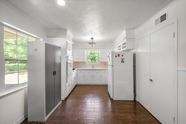 512 N 38th St, Corsicana, TX 75110 - kitchen with white appliances, a warming drawer, light countertops, white cabinetry, and dark wood-type flooring