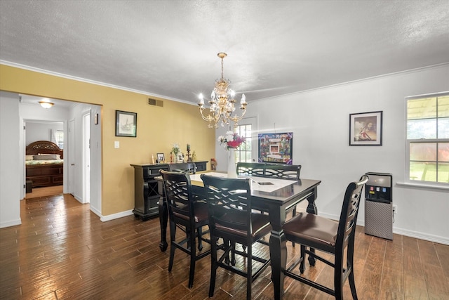 512 N 38th St, Corsicana, TX 75110 - dining area featuring a chandelier, dark wood-style floors, ornamental molding, baseboards, and a textured ceiling
