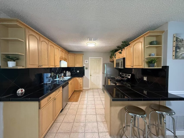 112 Plainview Dr, Wylie, TX 75098 - kitchen with open shelves, stainless steel appliances, a peninsula, a kitchen bar, and backsplash