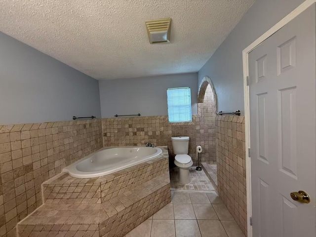 112 Plainview Dr, Wylie, TX 75098 - full bath with tile walls, tile patterned floors, toilet, a bath, and wainscoting