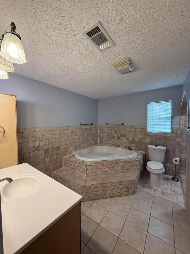 112 Plainview Dr, Wylie, TX 75098 - bathroom featuring tile walls, a wainscoted wall, tile patterned floors, a bath, and vanity