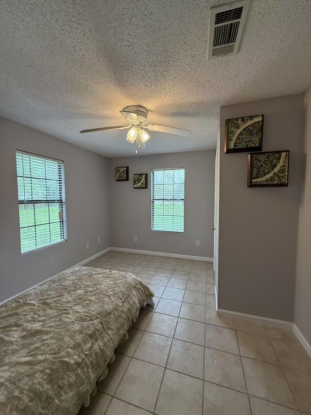 112 Plainview Dr, Wylie, TX 75098 - bedroom featuring light tile patterned floors, a textured ceiling, a ceiling fan, and baseboards