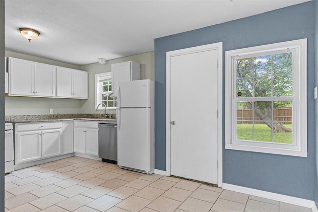 3508 Valencia Ct, Fort Worth, TX 76116 - kitchen with white appliances, white cabinetry, a sink, baseboards, and light stone countertops