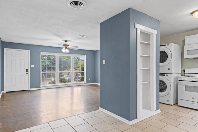 3508 Valencia Ct, Fort Worth, TX 76116 - laundry area featuring stacked washer and clothes dryer, a ceiling fan, baseboards, a textured ceiling, and light tile patterned floors