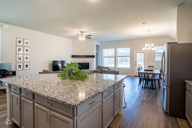 4714 Crestwood Dr, Haltom City, TX 76137 - kitchen with freestanding refrigerator, gray cabinets, a ceiling fan, dark wood-style flooring, and a fireplace