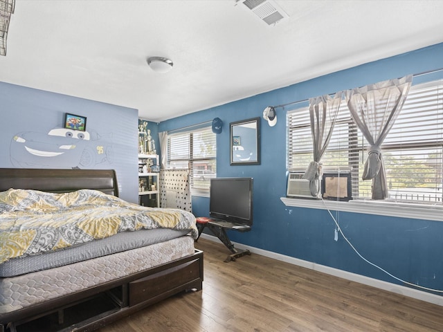 707 Washington St, Ennis, TX 75119 - bedroom with baseboards and wood finished floors