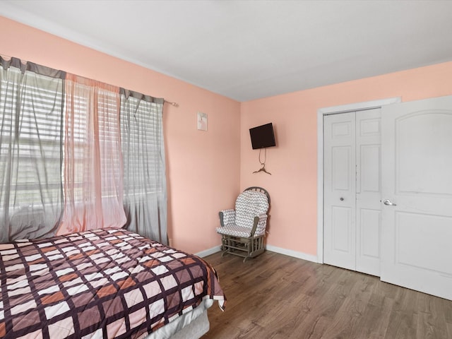 707 Washington St, Ennis, TX 75119 - bedroom with wood finished floors, baseboards, and a closet