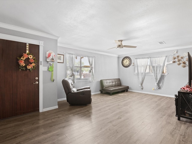 707 Washington St, Ennis, TX 75119 - living area featuring wood finished floors, ceiling fan, crown molding, and baseboards