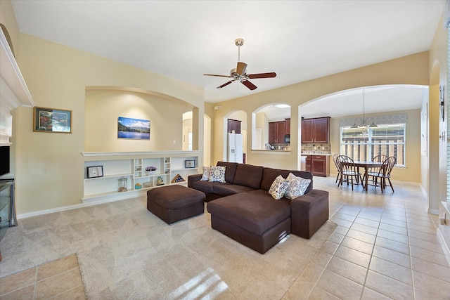 676 Woodland Way, Rockwall, TX 75087 - living area with light tile patterned floors, ceiling fan, arched walkways, and baseboards