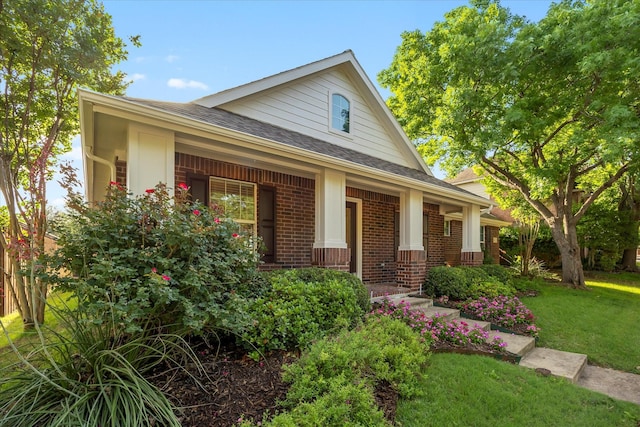 676 Woodland Way, Rockwall, TX 75087 - view of front of home featuring brick siding, a porch, a front lawn, and a shingled roof