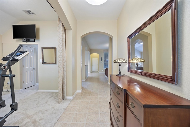 676 Woodland Way, Rockwall, TX 75087 - hallway with arched walkways, baseboards, light carpet, and light tile patterned floors