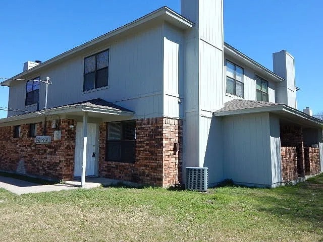 1906 N 4th St, Killeen, TX 76541 - rear view of house with brick siding, a chimney, a lawn, and cooling unit