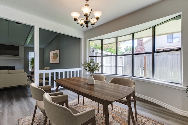 2513 Figtree Ln, Plano, TX 75074 - dining room with a chandelier, wood finished floors, baseboards, lofted ceiling, and a fireplace
