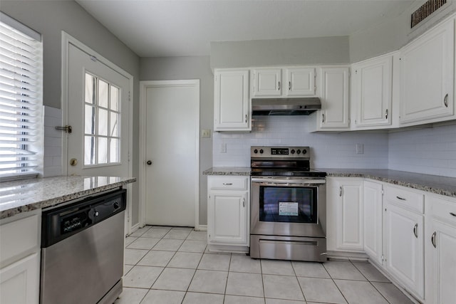 2513 Figtree Ln, Plano, TX 75074 - kitchen with appliances with stainless steel finishes, under cabinet range hood, decorative backsplash, white cabinets, and light tile patterned flooring