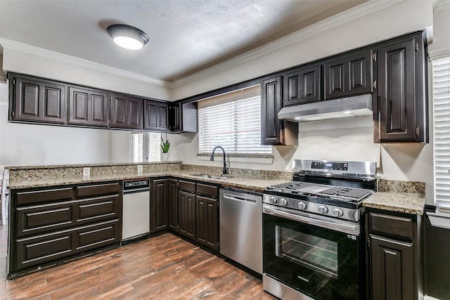 1017 Meadowbrook Dr, Grapevine, TX 76051 - kitchen with appliances with stainless steel finishes, under cabinet range hood, a sink, crown molding, and light stone counters