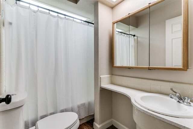 1017 Meadowbrook Dr, Grapevine, TX 76051 - bathroom with a sink, toilet, wood finished floors, and shower / tub combo