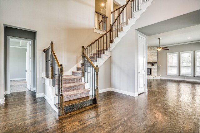 344 Redstone Dr, Sunnyvale, TX 75182 - stairway with a ceiling fan, a fireplace, wood finished floors, baseboards, and a towering ceiling