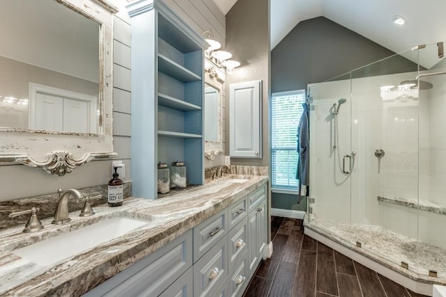 10613 Raleigh Dr, Frisco, TX 75035 - full bath featuring a shower stall, vaulted ceiling, double vanity, wood finished floors, and a chandelier