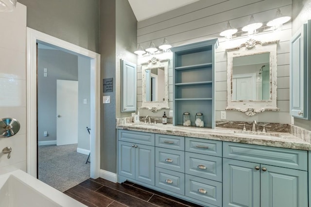 10613 Raleigh Dr, Frisco, TX 75035 - bathroom featuring baseboards, double vanity, and wood tiled floors
