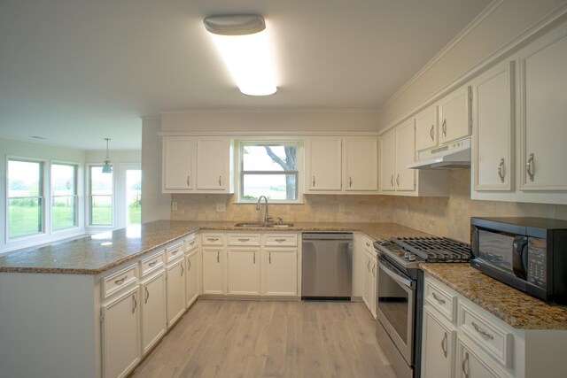 812 Crestline Dr, Mexia, TX 76667 - kitchen with stainless steel appliances, under cabinet range hood, a sink, a peninsula, and white cabinets