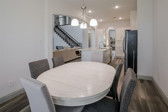 12959 Averi Ln, Farmers Branch, TX 75234 - dining area featuring arched walkways, dark wood-style flooring, baseboards, a chandelier, and recessed lighting