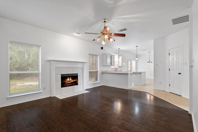 5919 Wisdom Creek Dr, Dallas, TX 75249 - unfurnished living room with a sink, ceiling fan, a tile fireplace, and light wood finished floors