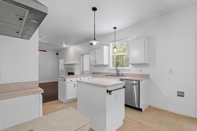 5919 Wisdom Creek Dr, Dallas, TX 75249 - kitchen with stainless steel dishwasher, light countertops, light tile patterned flooring, white cabinetry, and a peninsula
