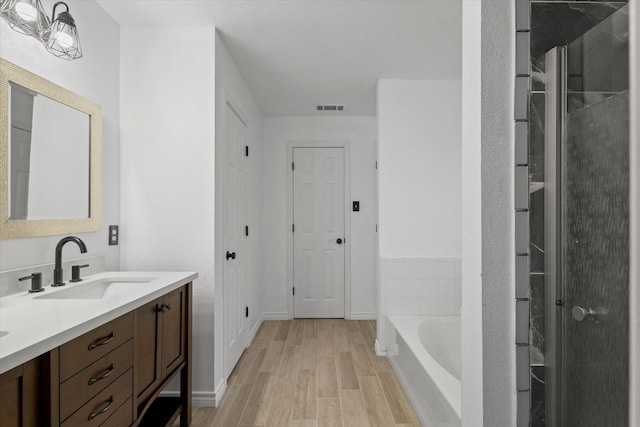5919 Wisdom Creek Dr, Dallas, TX 75249 - full bath with wood finished floors, vanity, a bath, and baseboards