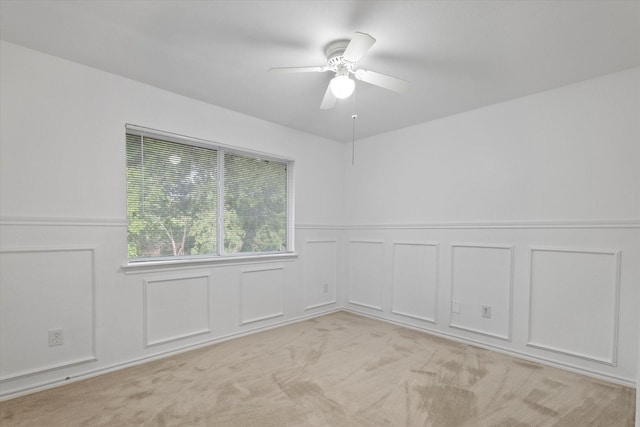 5919 Wisdom Creek Dr, Dallas, TX 75249 - spare room with a decorative wall, ceiling fan, wainscoting, and light colored carpet