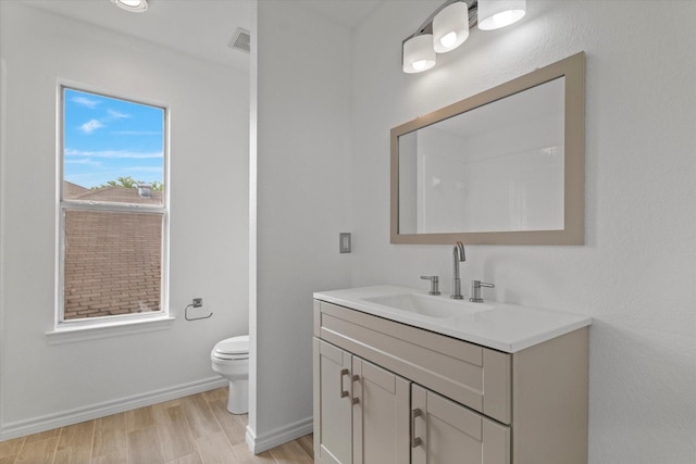 5919 Wisdom Creek Dr, Dallas, TX 75249 - bathroom featuring wood finished floors, toilet, vanity, and baseboards