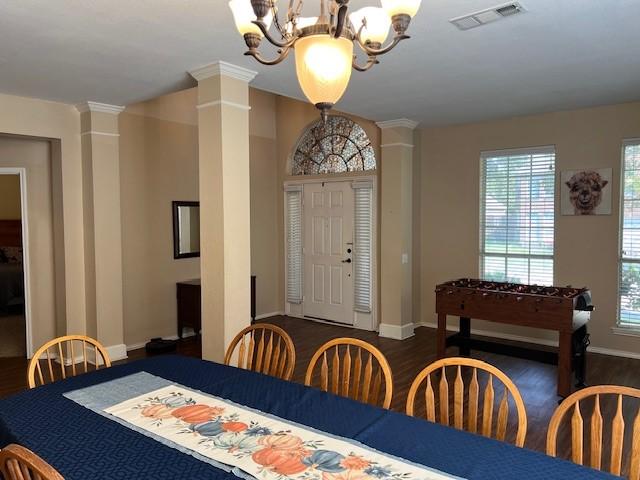 1275 Calistoga Dr, Rockwall, TX 75087 - dining area with decorative columns, a chandelier, dark wood-style flooring, and baseboards
