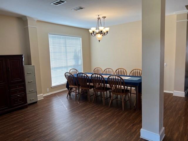 1275 Calistoga Dr, Rockwall, TX 75087 - dining room featuring dark wood-style flooring, a chandelier, baseboards, and decorative columns