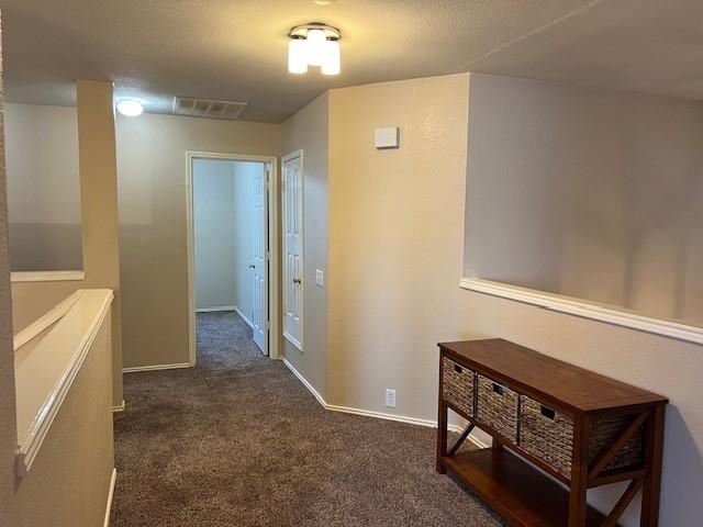 1275 Calistoga Dr, Rockwall, TX 75087 - hallway featuring dark carpet and baseboards