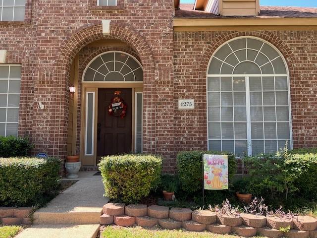 1275 Calistoga Dr, Rockwall, TX 75087 - view of exterior entry featuring brick siding