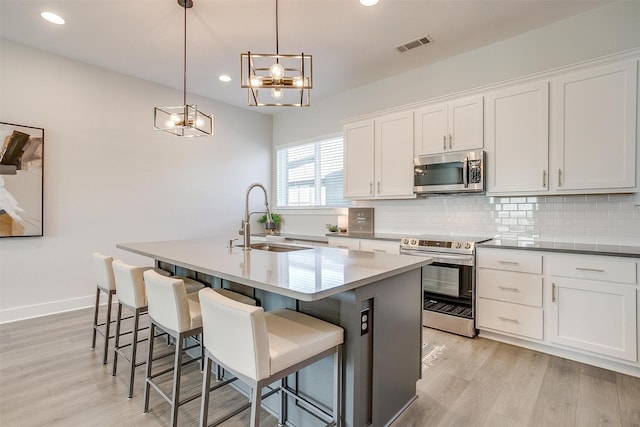 2818 Addison Park Ln, Fort Worth, TX 76110 - kitchen featuring stainless steel appliances, a sink, light wood-style flooring, decorative backsplash, and recessed lighting