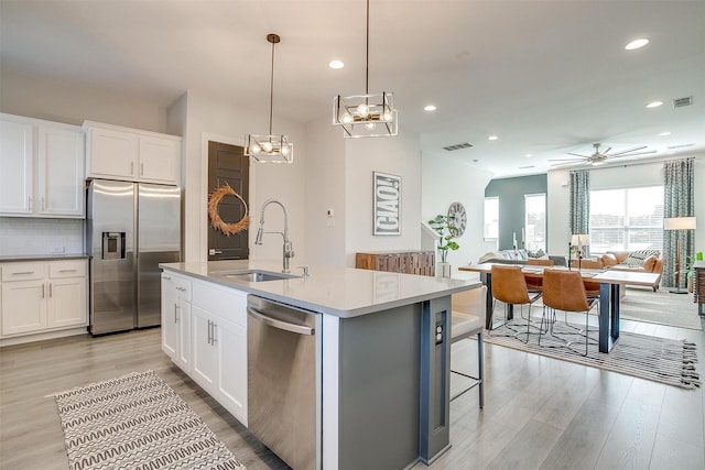 2818 Addison Park Ln, Fort Worth, TX 76110 - kitchen featuring stainless steel appliances, a sink, open floor plan, light wood finished floors, and recessed lighting