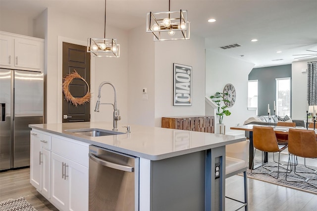 2818 Addison Park Ln, Fort Worth, TX 76110 - kitchen with appliances with stainless steel finishes, a sink, a chandelier, light wood-type flooring, and light countertops