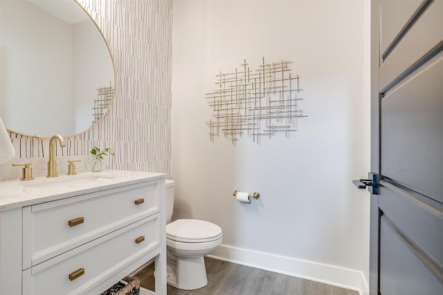 2818 Addison Park Ln, Fort Worth, TX 76110 - bathroom with baseboards, toilet, wood finished floors, and vanity